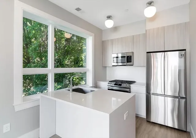 a kitchen with a refrigerator a stove and a sink