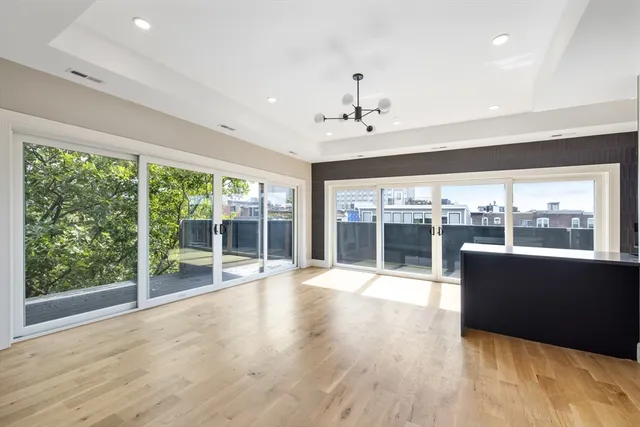 a view of an empty room with wooden floor and a floor to ceiling window