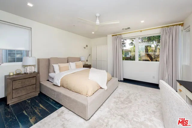 a large white bed sitting in a room next to a window