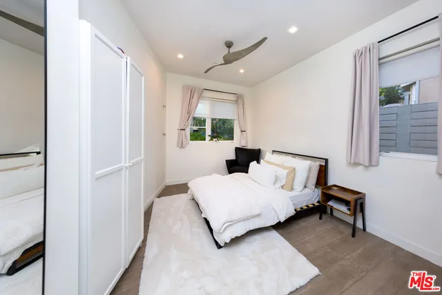 a bedroom with a bed lamp and a large window