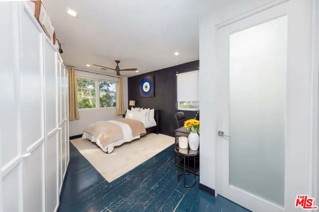 a bedroom with a bed and wooden floor