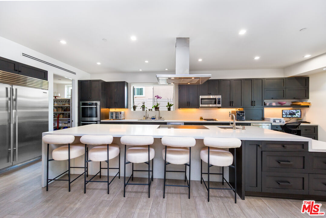 9401 Kirkside Road Los Angeles, CA 90035 - Photo 2 of 18 a kitchen with stainless steel appliances a table chairs refrigerator and microwave