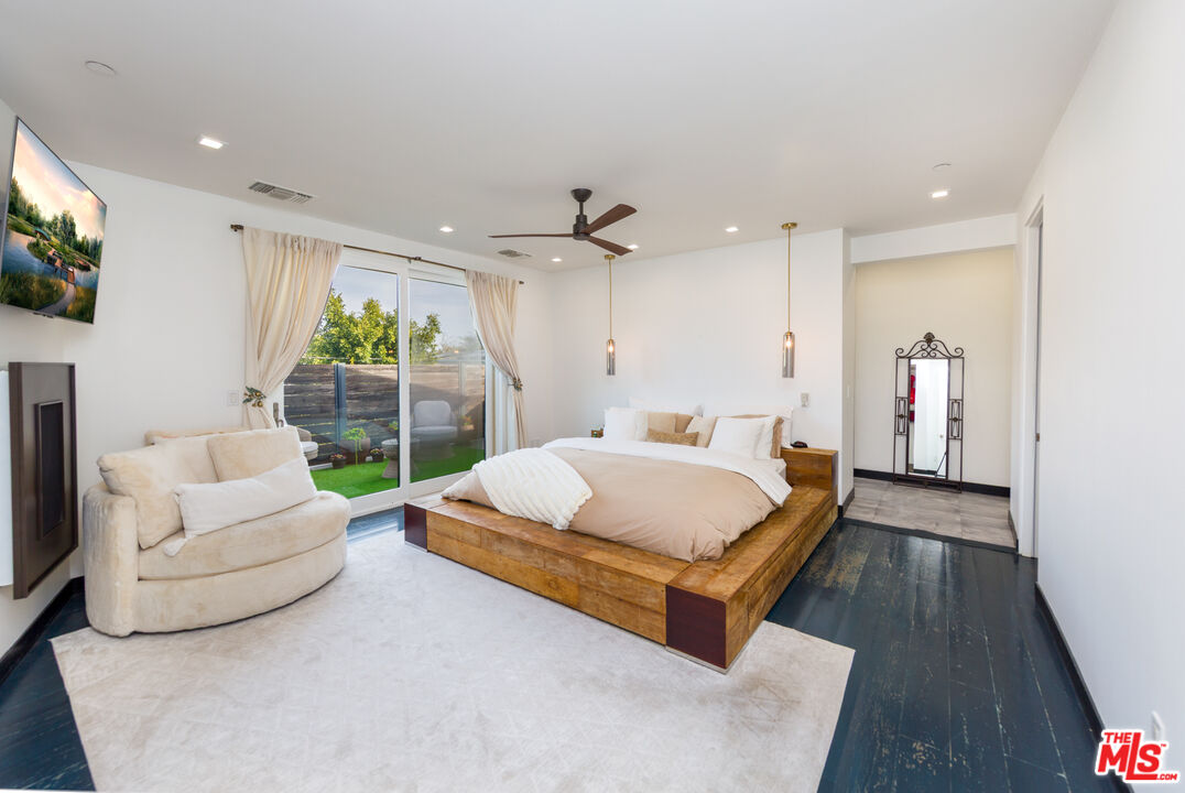 9401 Kirkside Road Los Angeles, CA 90035 - Photo 7 of 18 a spacious bedroom with a bed a couch and a flat tv screen