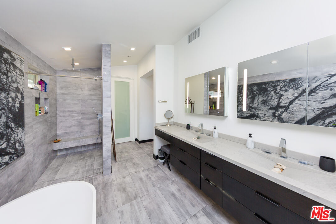 9401 Kirkside Road Los Angeles, CA 90035 - Photo 8 of 18 a bathroom with a double vanity sink a large mirror and shower