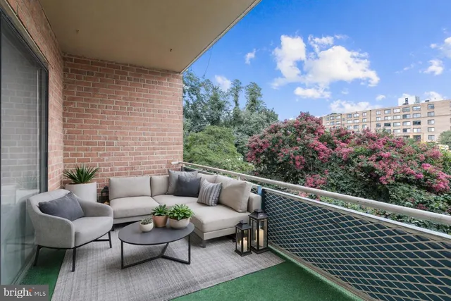 a view of a patio with couches table and chairs with potted plants