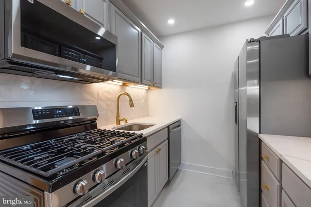 a stove top oven sitting inside of a kitchen