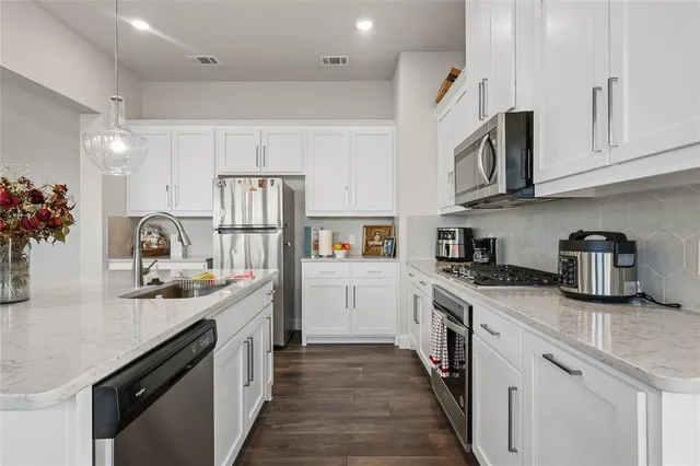 a kitchen with stainless steel appliances granite countertop a sink stove and refrigerator