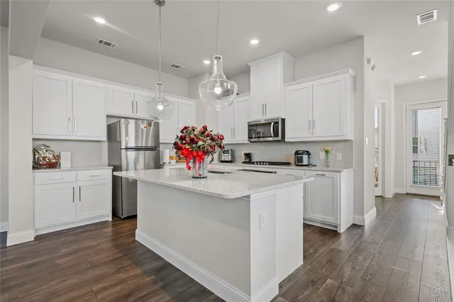 a kitchen with white cabinets and refrigerator