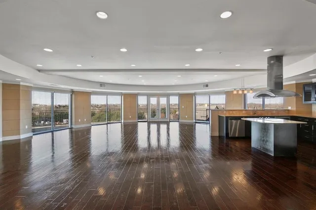 a view of empty room with kitchen and flat screen tv