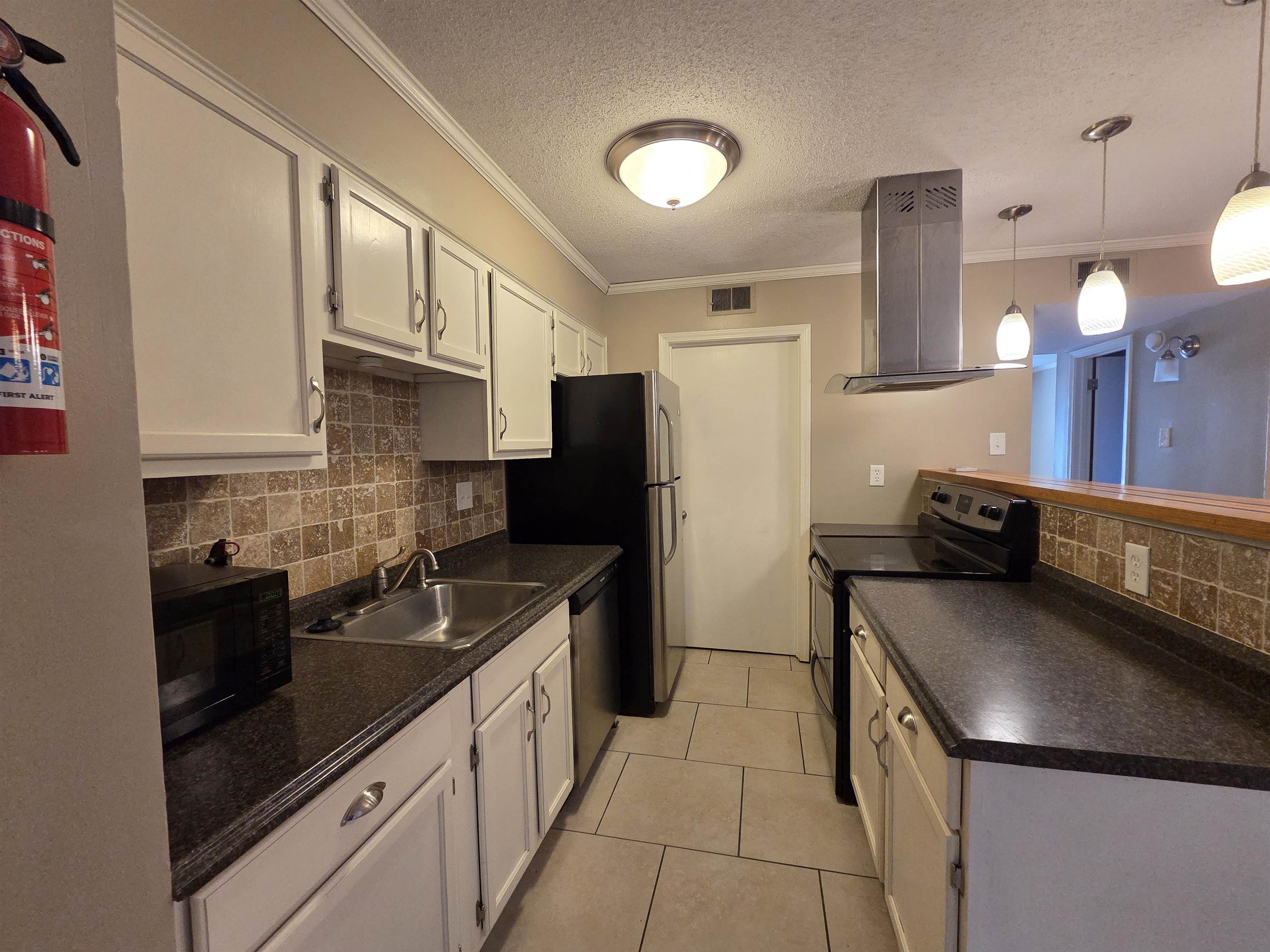 2104 Harbert Avenue Memphis, TN 38104 - Photo 16 of 26 a kitchen with stainless steel appliances granite countertop a sink stove and refrigerator