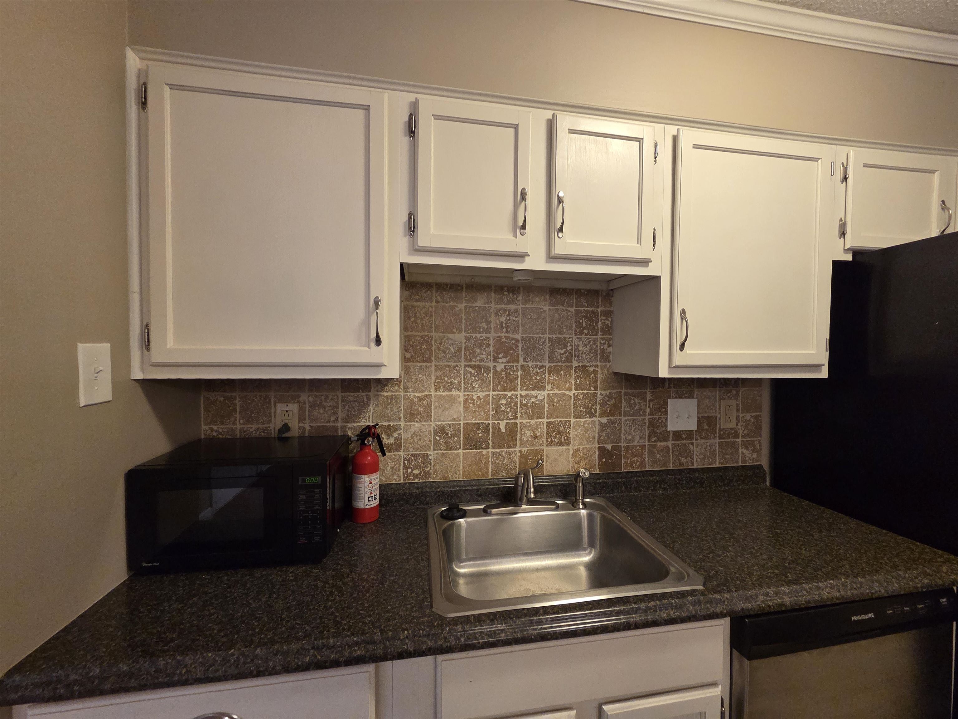 2104 Harbert Avenue Memphis, TN 38104 - Photo 17 of 26 Kitchen featuring white cabinetry, stainless steel appliances, dark countertops, and tasteful backsplash
