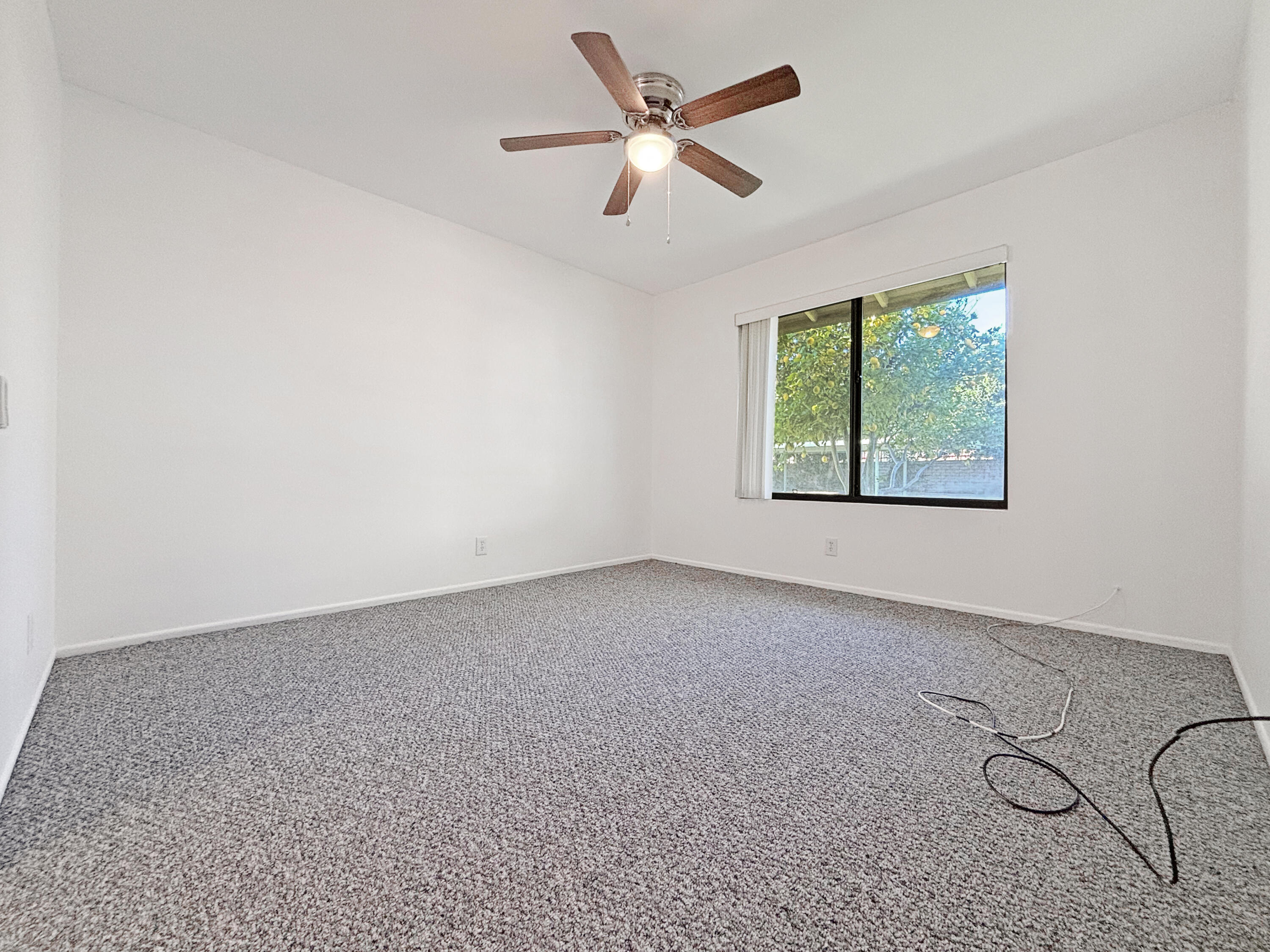 63 Lakeview Circle Cathedral City, CA 92234 - Photo 7 of 15 an empty room with fan and windows