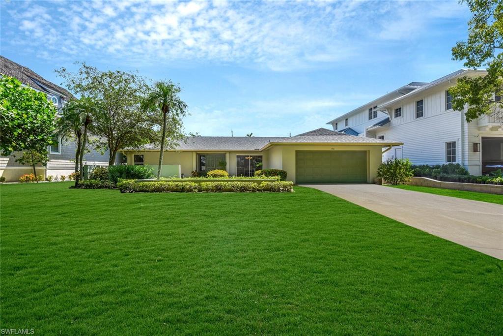 a front view of a house with a yard and trees