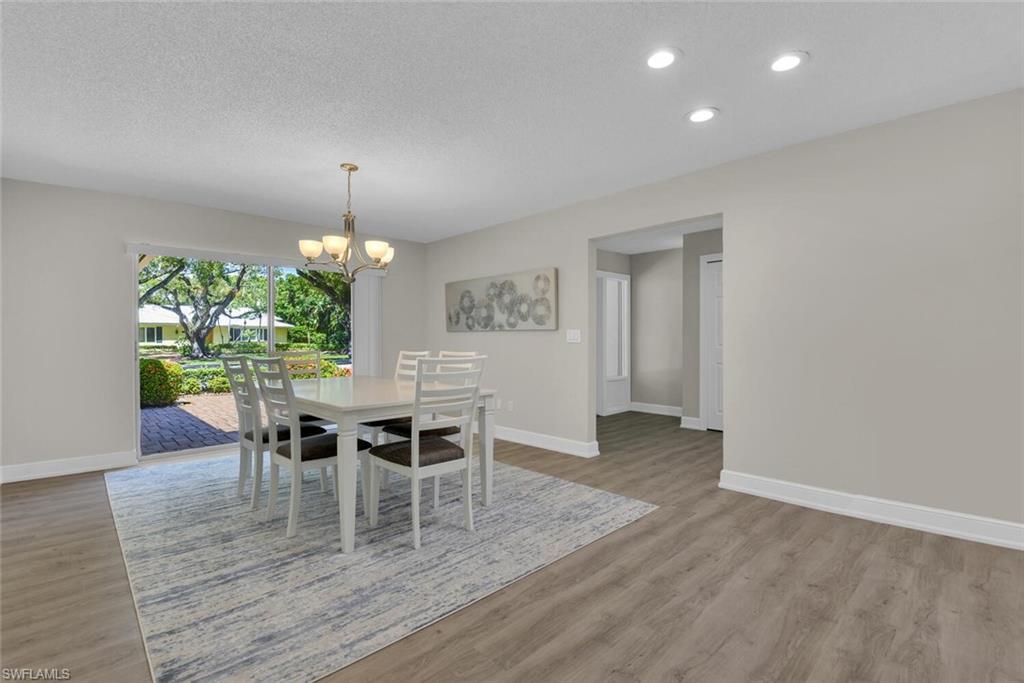 150 1st Avenue North Naples, FL 34102 - Photo 12 of 44 a view of a dining room with furniture and wooden floor