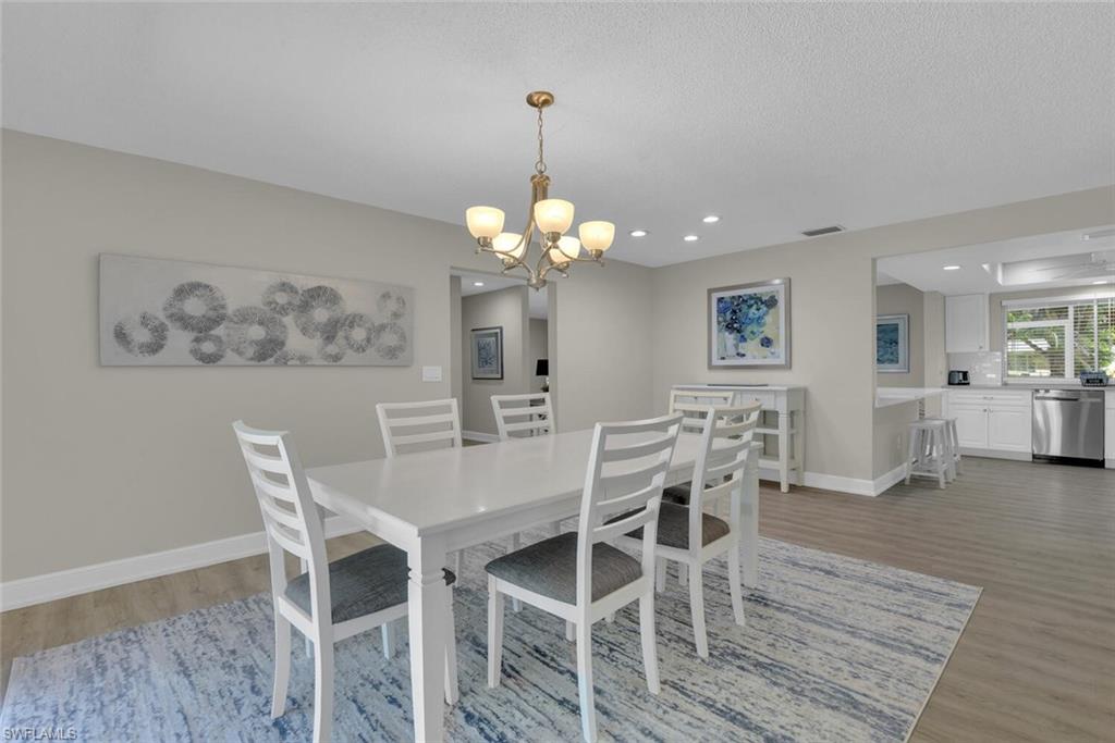 150 1st Avenue North Naples, FL 34102 - Photo 14 of 44 a view of a dining room with furniture and wooden floor