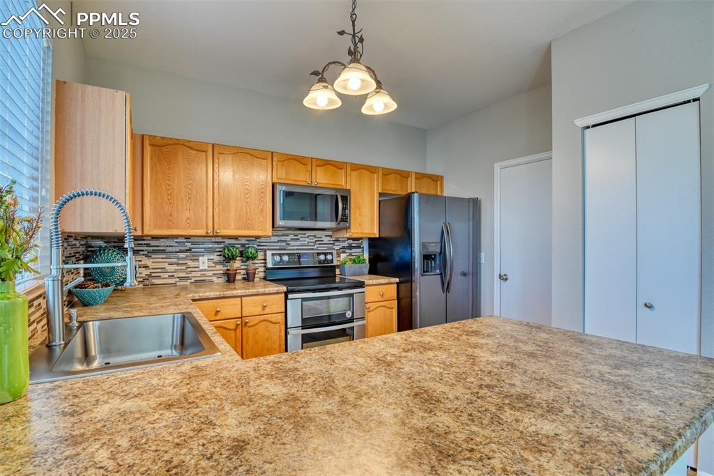 6810 Shore View Colorado Springs, CO 80922 - Photo 13 of 48 a kitchen with stainless steel appliances granite countertop a stove refrigerator and a sink