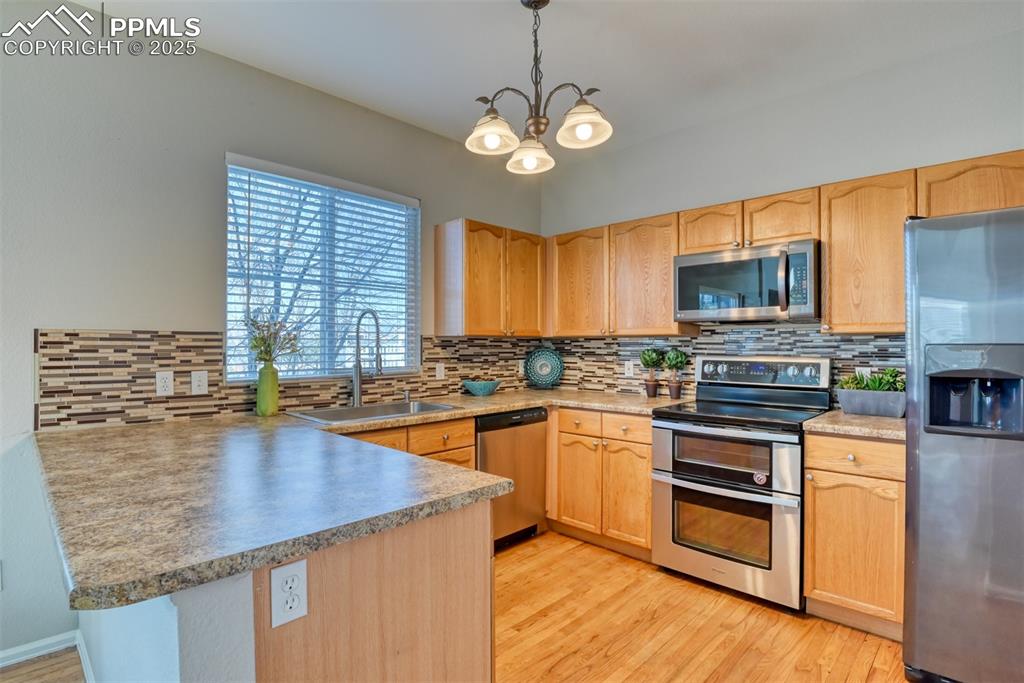 6810 Shore View Colorado Springs, CO 80922 - Photo 14 of 48 a kitchen with stainless steel appliances granite countertop a sink stove and microwave