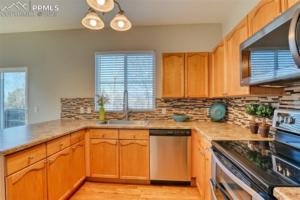 6810 Shore View Colorado Springs, CO 80922 - Photo 15 of 48 a kitchen with stainless steel appliances granite countertop a sink a stove and a microwave