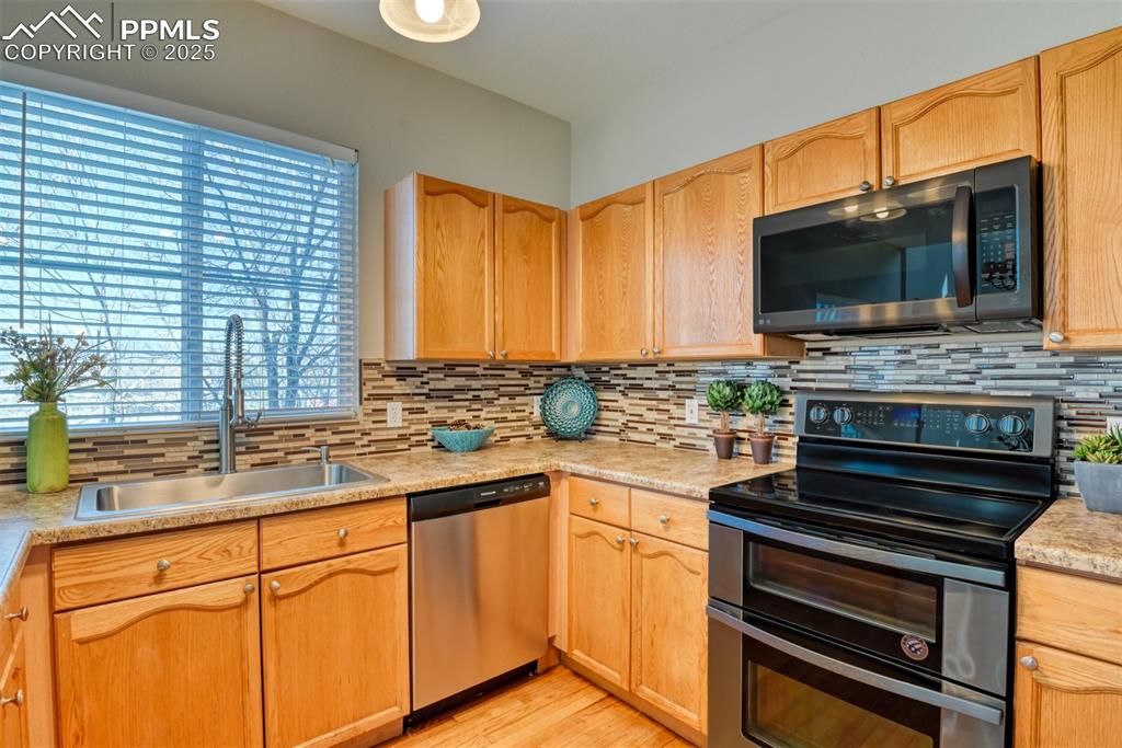 6810 Shore View Colorado Springs, CO 80922 - Photo 17 of 48 a kitchen with stainless steel appliances a stove sink and microwave