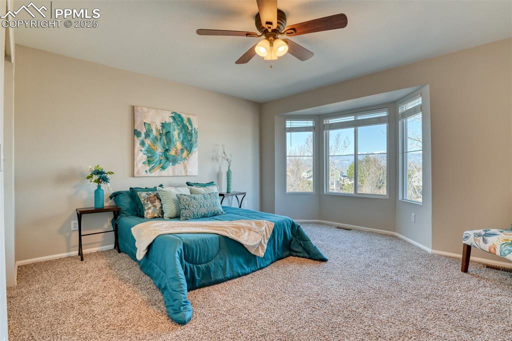 6810 Shore View Colorado Springs, CO 80922 - Photo 20 of 48 a bedroom with a bed a chandelier and a window