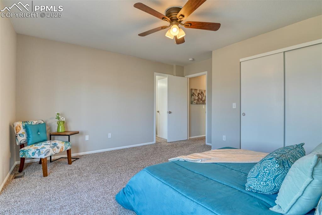 6810 Shore View Colorado Springs, CO 80922 - Photo 22 of 48 a bedroom with a bed and a chandelier