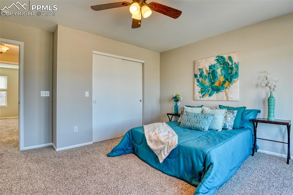 6810 Shore View Colorado Springs, CO 80922 - Photo 23 of 48 a bedroom with a bed and a chandelier