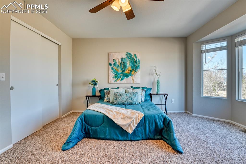 6810 Shore View Colorado Springs, CO 80922 - Photo 24 of 48 a bedroom with a bed and a chandelier