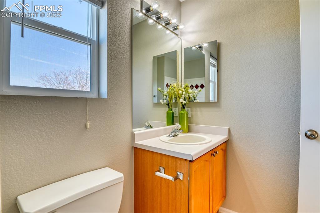 6810 Shore View Colorado Springs, CO 80922 - Photo 36 of 48 a bathroom with a toilet sink and mirror