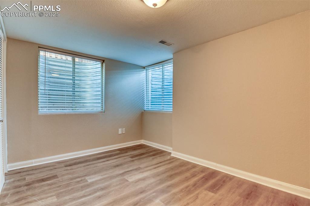 6810 Shore View Colorado Springs, CO 80922 - Photo 41 of 48 an empty room with wooden floor and windows