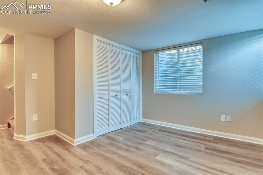 6810 Shore View Colorado Springs, CO 80922 - Photo 42 of 48 a view of an empty room with wooden floor and a window