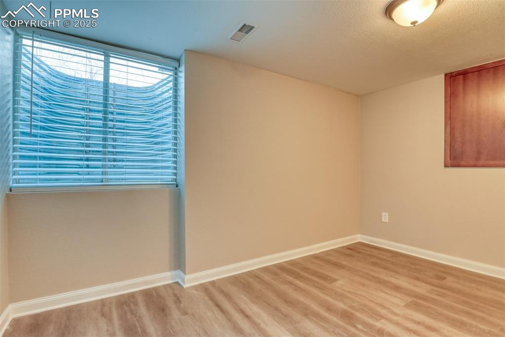 6810 Shore View Colorado Springs, CO 80922 - Photo 43 of 48 an empty room with wooden floor and windows
