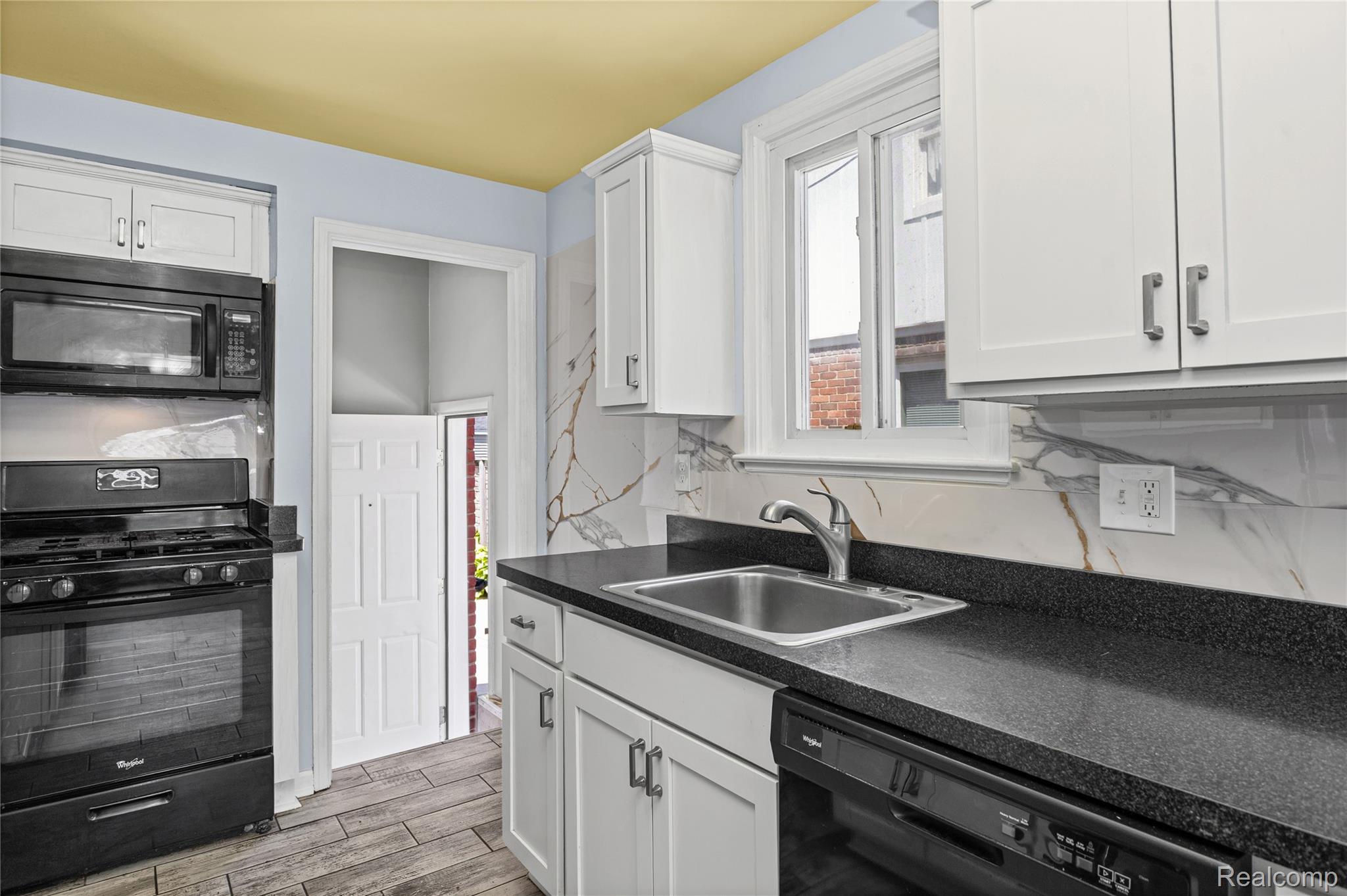 26508 Five Mile Road Redford, MI 48239 - Photo 16 of 41 Kitchen featuring white shaker cabinetry, dark countertops, and a white and gold backsplash