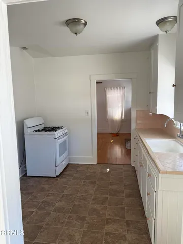 a view of an empty room with kitchen