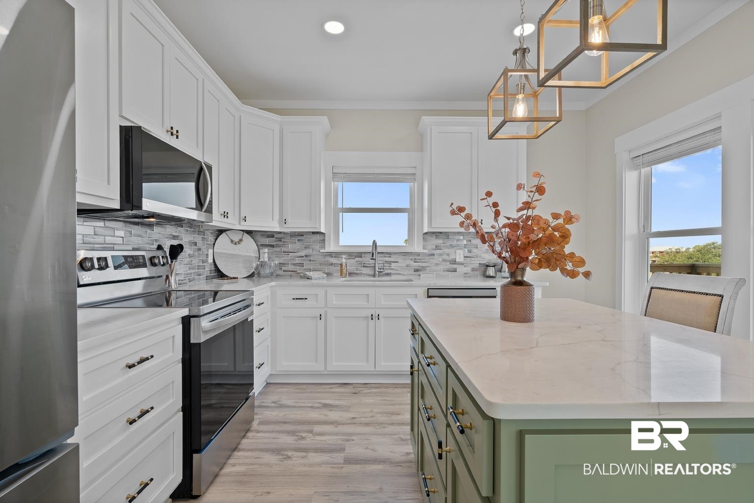 2586 Muscogee Road Gulf Shores, AL 36542 - Photo 3 of 55 Kitchen with white cabinetry, appliances with stainless steel finishes, light stone counters, and a kitchen island