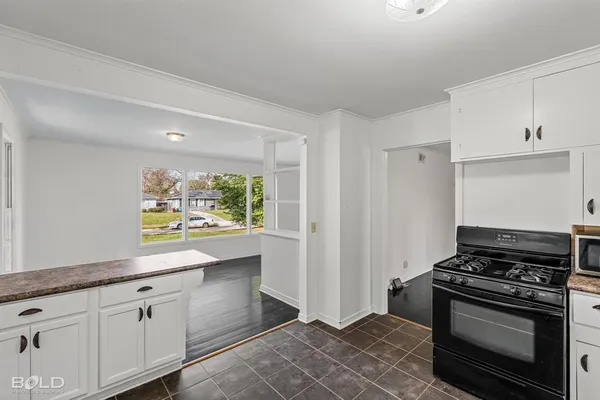 a kitchen with stainless steel appliances a stove and white cabinets