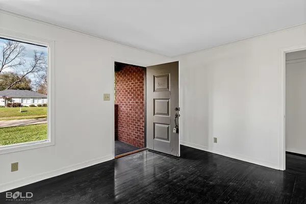 an empty room with windows closet and fire place