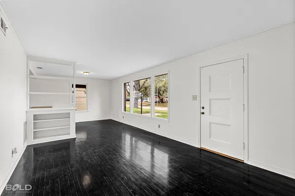 wooden floor in an empty room with a window
