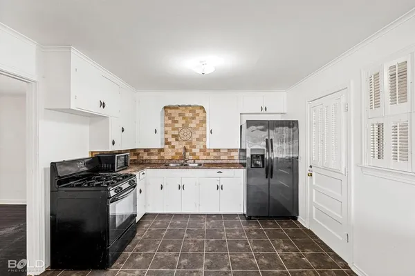 a kitchen with granite countertop a refrigerator stove and sink