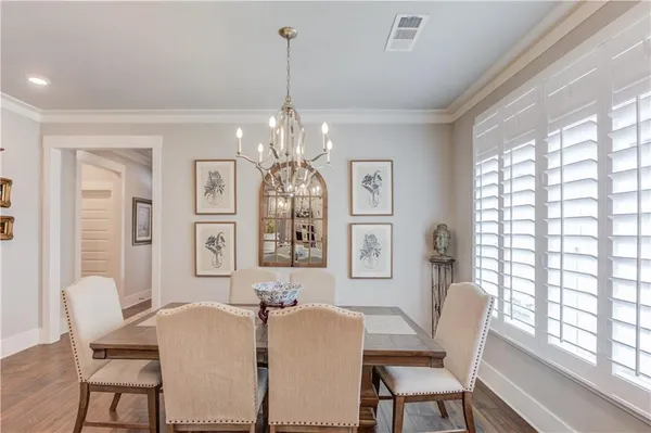 a view of a dining room with furniture a chandelier and wooden floor