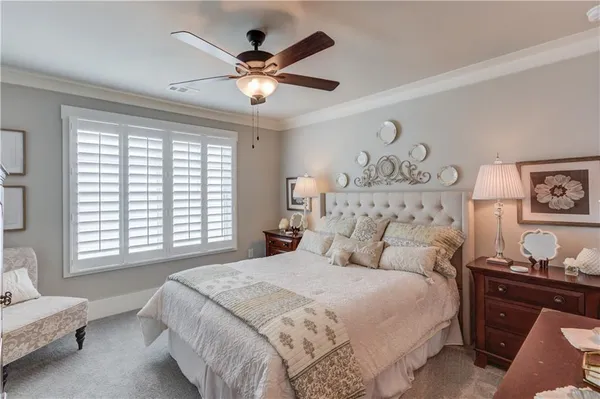 a bedroom with a large bed and a chandelier