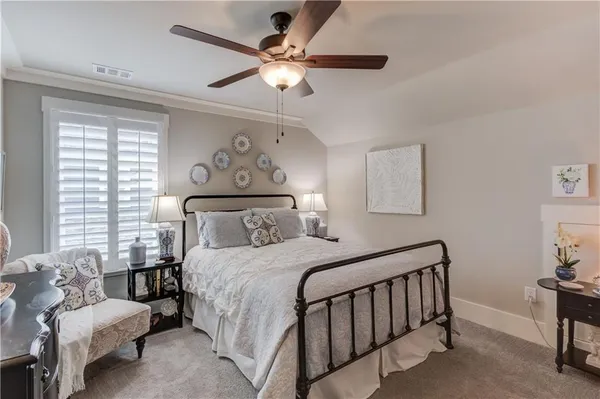 a bedroom with a large bed and a chandelier