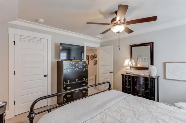 a room with a bed and a flat tv screen on dresser