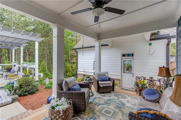 a living room with patio furniture and potted plants