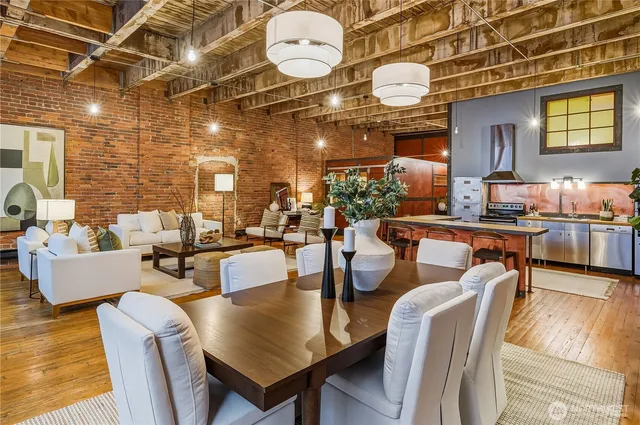a living room with furniture and a dining table with potted plants