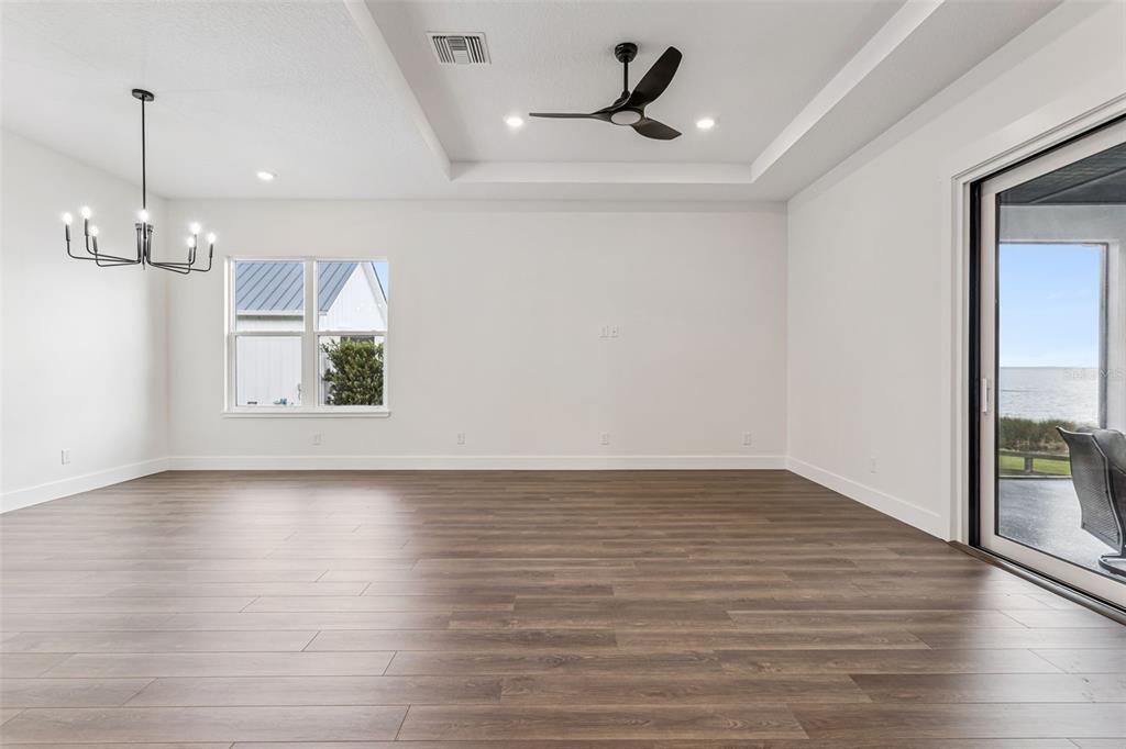 17540 3rd Street Montverde, FL 34756 - Photo 20 of 80 a view of a room with wooden floor a ceiling fan and windows