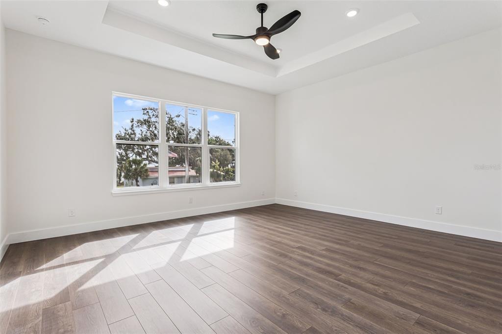 17540 3rd Street Montverde, FL 34756 - Photo 28 of 80 an empty room with wooden floor ceiling fan and windows