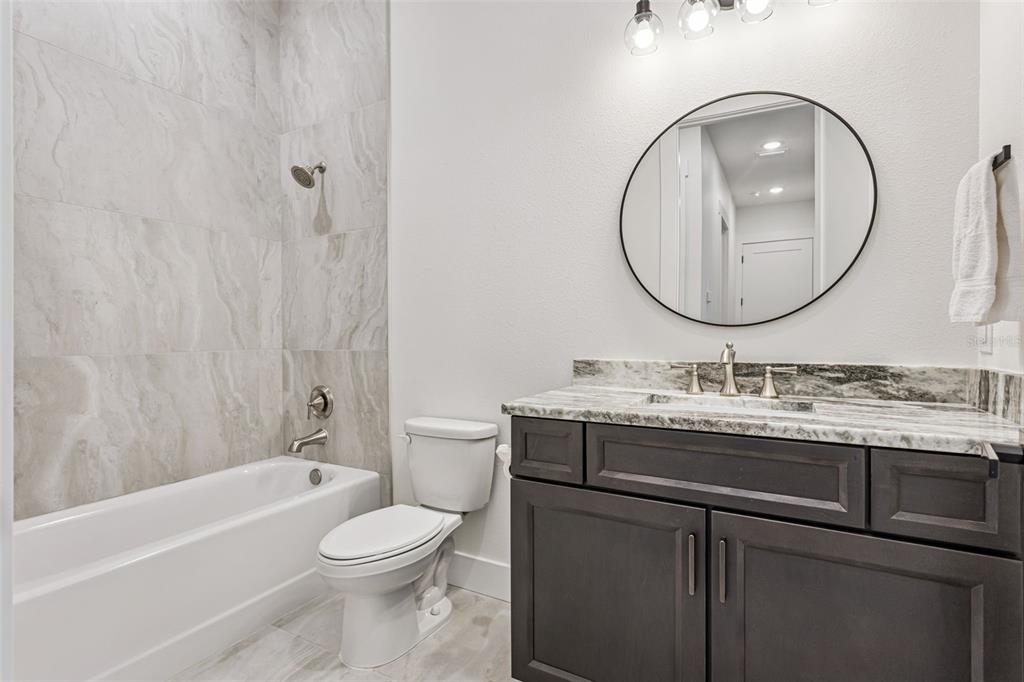 17540 3rd Street Montverde, FL 34756 - Photo 39 of 80 a bathroom with a granite countertop toilet a sink and a mirror