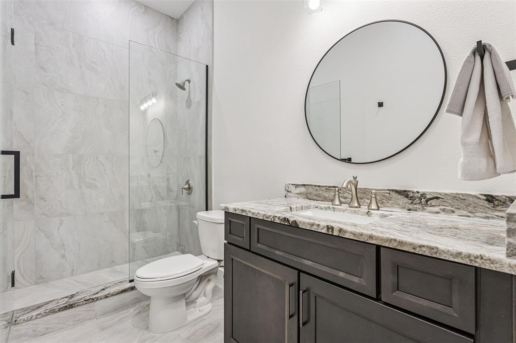 17540 3rd Street Montverde, FL 34756 - Photo 40 of 80 a bathroom with a granite countertop toilet sink and mirror