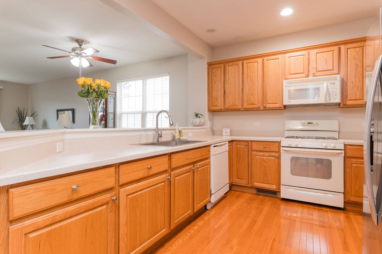 13822 Chestnut Lane Huntley, IL 60142 - Photo 7 of 43 a kitchen with stainless steel appliances granite countertop a sink cabinets and wooden floor