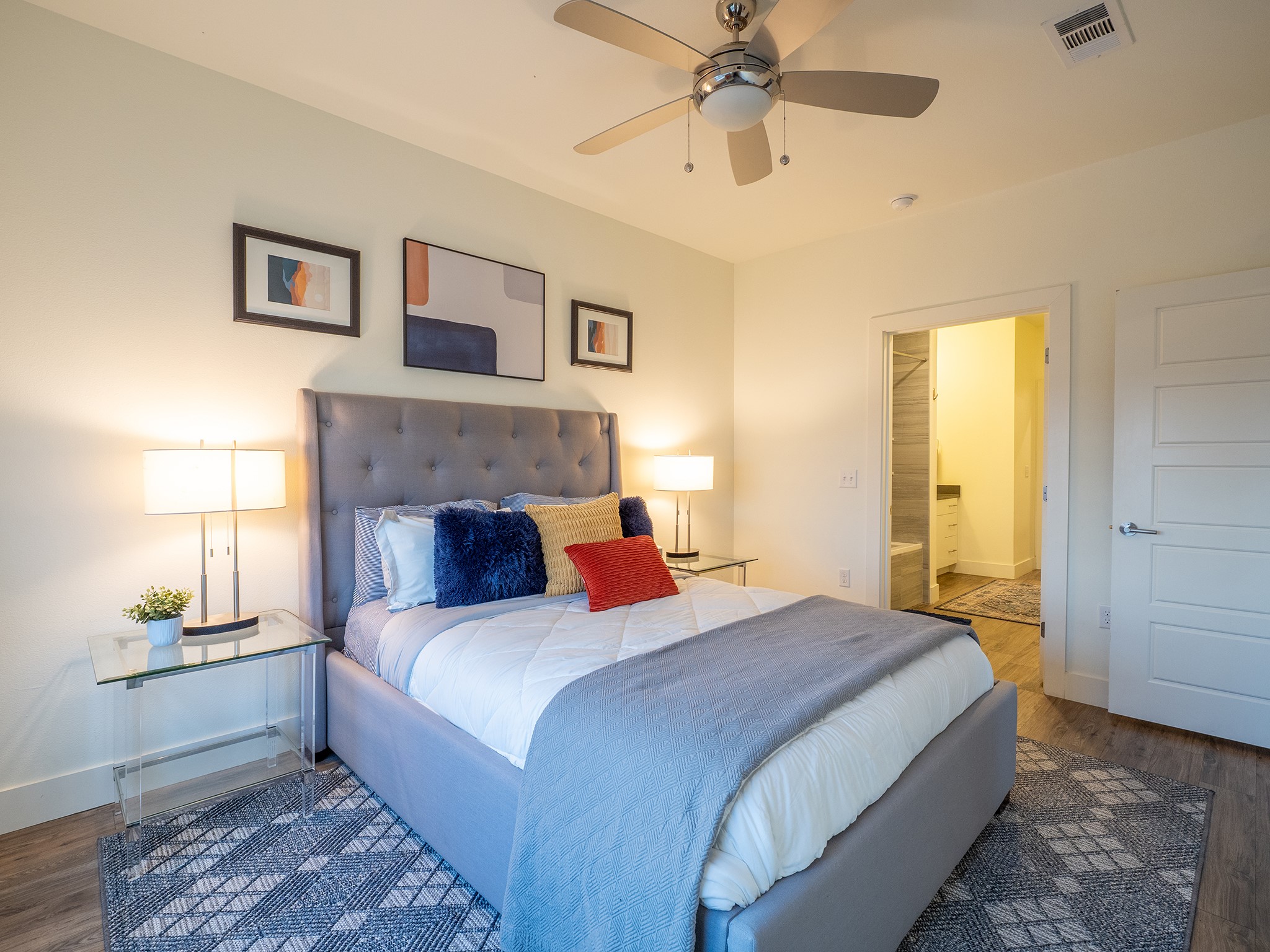 6444 Burnet Road, Unit 509 Austin, TX 78757 - Photo 15 of 32 Well-lit sleeping quarters with a ceiling fan, wood flooring, and direct access to an attached bathroom.